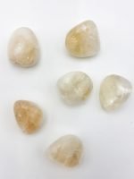 Five pieces of TUMBLED CITRINE QUARTZ on a white surface.