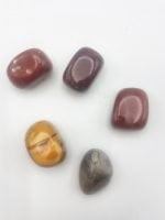 A group of MOOKAITE stones TUMBLED on a white surface.