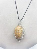 A SPIRAL necklace with a yellow stone encased in a metal cage STEEL CAGE FOR STONES.