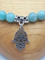 Un braccialetto di amazzonite con un amuleto hamsa.