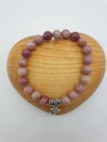 A pink stone bracelet with a silver pendant.