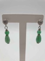 Green aventurine earrings on a stand.