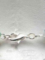 A MUSKY AGATE MEN'S NECKLACE, FREE FROM CHAINS adorned with a green stone is intended to FREE FROM CHAINS.