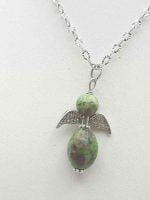 A RUBY ZOISITE ANGEL PENDANT with a green stone.