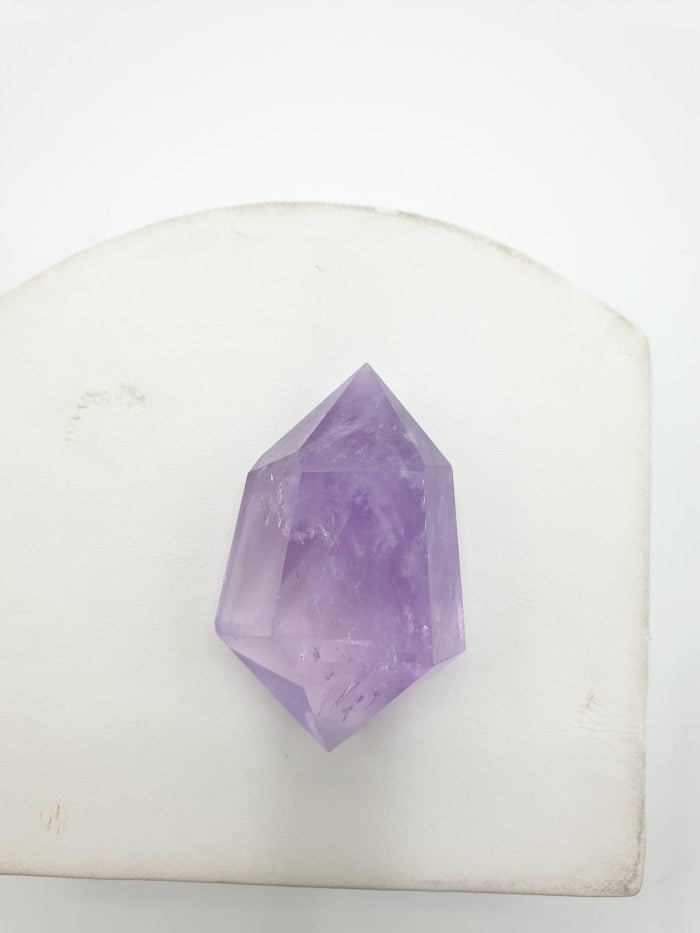 A crystal BITERMINATED AMETHYST TIPS, lying on a white table.