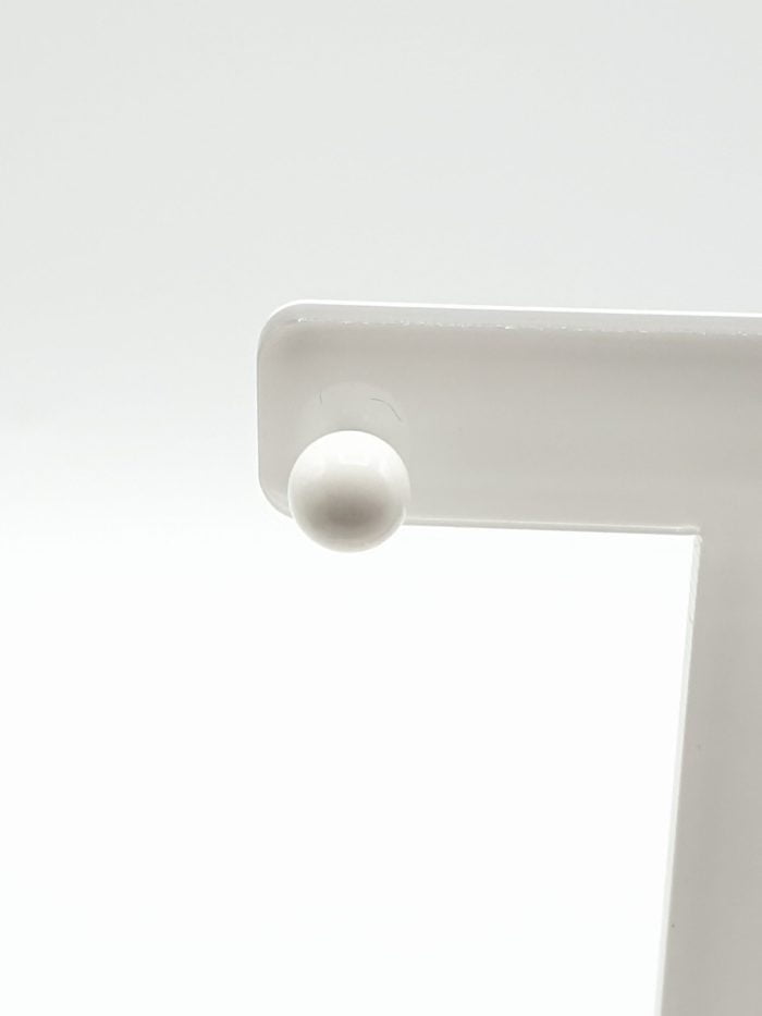 Close-up of a white plastic knob on white surface with EARRINGS WITH WHITE AGATE 6 MM IN STERLING SILVER.