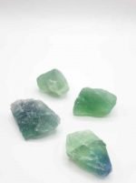 Four pieces of RAW RAINBOW FLUORITE green and blue on a white background.