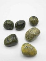 A collection of ASTERITE OR TUMBLED SERPENTINE stones on a white surface.