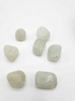 A group of white stones on a white surface, similar to TUMBLED PRASIOLITE.