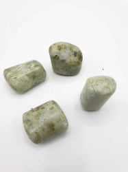 Quattro pietre verdi VESUVIANITE O VASONITE BURATTATA su fondo bianco.