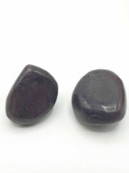 Two TUMBLED RUBY stones on a white background.