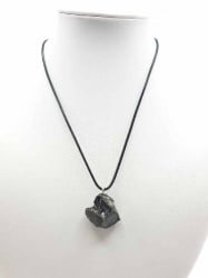 Una collana CIONDOLO DI SHUNGITE ELITE con sopra una pietra nera.