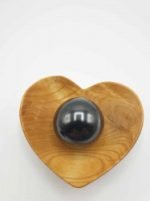 Una perla nera in una ciotola di legno a forma di SFERA DI SHUNGITE 4 CM.