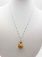 A mookaite pendant on a mannequin.
