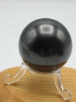 PLEXIGLASS PEDESTAL DISPLAY FOR BALL SUPPORT black exposed on a wooden support on a plexiglass pedestal.