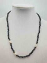 A MEN'S NECKLACE WITH LAVA STONE AND HOWLITE with black onyx pearls and howlite pearls.