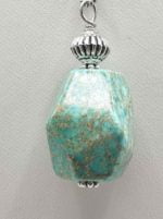 Un ciondolo pendente di diaspro imperiale sospeso da una catena d'argento.