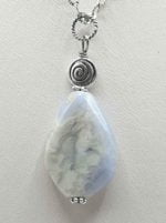 A blue CHALCEDONY PENDANT PENDANT on a silver chain.
