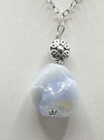 A blue CHALCEDONY PENDANT PENDANT on a silver chain.