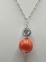 A necklace with a coral ball and a silver ball, characterized by the CORAL BAMBOO PENDANT PENDANT.