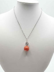 A CORAL BAMBOO PENDANT showing a bamboo coral bead on a mannequin.