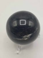 BLACK TOURMALINE SPHERE on a white surface.