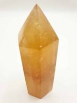 A GOLDEN YELLOW CALCITE OBELISK TIP on a white background.