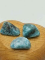 Three pieces of blue LARIMAR TURAPAT on top of a wooden heart.