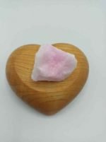 A Raw Pink Aragonite crystal in a wooden heart.