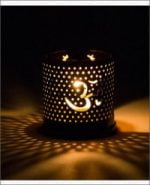 A metal candle holder with the Aromafume symbol on it burns Ohm incense.