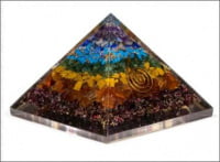 UNA PIRAMIDE DI ORGONITE 7 CHAKRA composta da pietre colorate e cristalli.