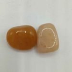 Two pieces of jade RED AVENTURINE TUMBLED orange on a white background.