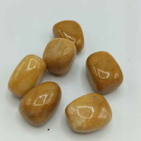 A group of TUMBLED YELLOW JADE stones on a TUMBLED surface.