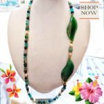 A mannequin wearing GREEN AGATE, PEARLS, CHRYSOCOLLA AND HEMATITE NECKLACE with green beads and flowers in green agate and chrysocolla.