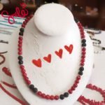 A BAMBOO CORAL AND BLACK LAVA STONE NECKLACE on a mannequin.