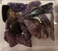 Purple amethyst crystals in a plastic container decorated with CHAROITE TUMBLED STICK.