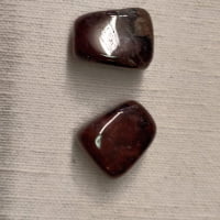A pair of PIERTERSITE TUMBLED stones on a white surface.